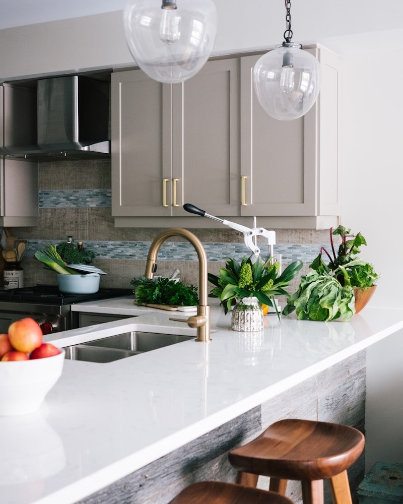 Bright modern San Francisco kitchen renovation with brass fixtures, white quartz counter, and pendant lighting